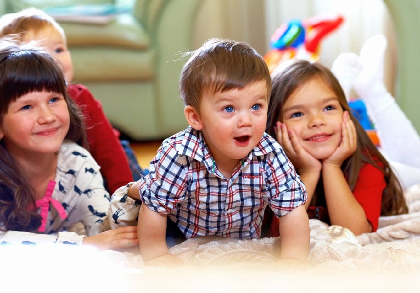 group of happy kids watching tv at home